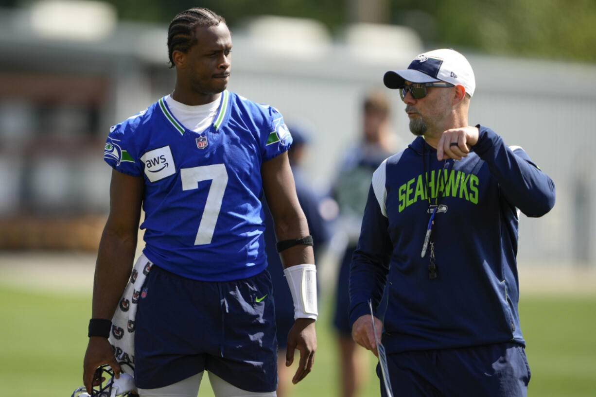 Seattle Seahawks quarterback Geno Smith says new offensive coordinator Ryan Grubb, right, has developed an offense that can stretch the field or give options for shorter success.