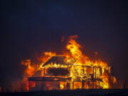 A home burns after a fast-moving wildfire swept through the area in the Centennial Heights neighborhood of Louisville, Colorado on Thursday, Dec. 30, 2021. U.S. homeowners&Ccedil;&fnof;&Ugrave; wildfire and flood risks are underinsured by $28.7 billion a year.