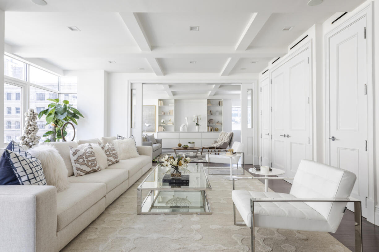 Various shades of white including a winter white sofa and area rug helps to create a look that is crisp and clean.