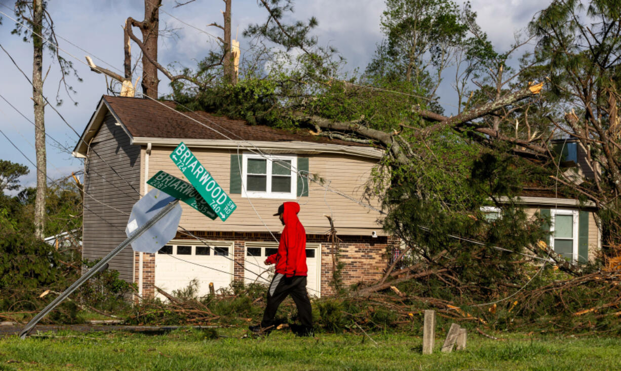 Monta Lemons on Briarwood Road surveys the damage after a night of turbulent storms. Cleanup efforts were underway April 3 in Rockdale County, where at least one tornado was reported to have touched down and left a path of destruction.