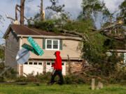 Monta Lemons on Briarwood Road surveys the damage after a night of turbulent storms. Cleanup efforts were underway April 3 in Rockdale County, where at least one tornado was reported to have touched down and left a path of destruction.