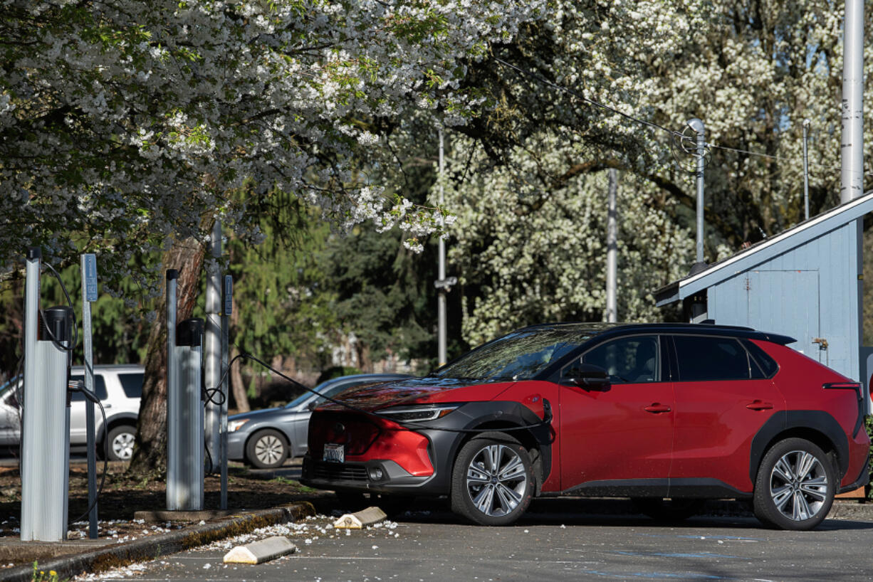 An electric vehicle charges at the electric charging station at Clark Public Utilities in April. Several consumers say they have had trouble redeeming the state&rsquo;s new EV rebate.