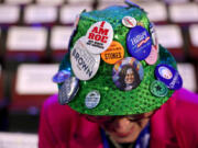 Ohio celebration committee member Helen Sheehan shows her hat with political buttons on the floor of the 2024 Democratic National Convention on Monday in Chicago.