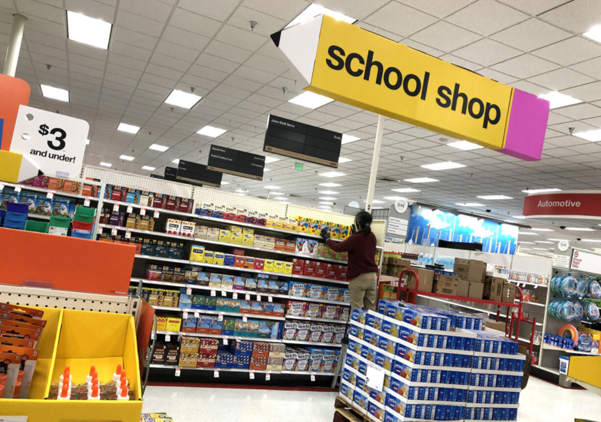 A worker stocks shelves of back-to-school supplies at a Target store in Colma, Calif.