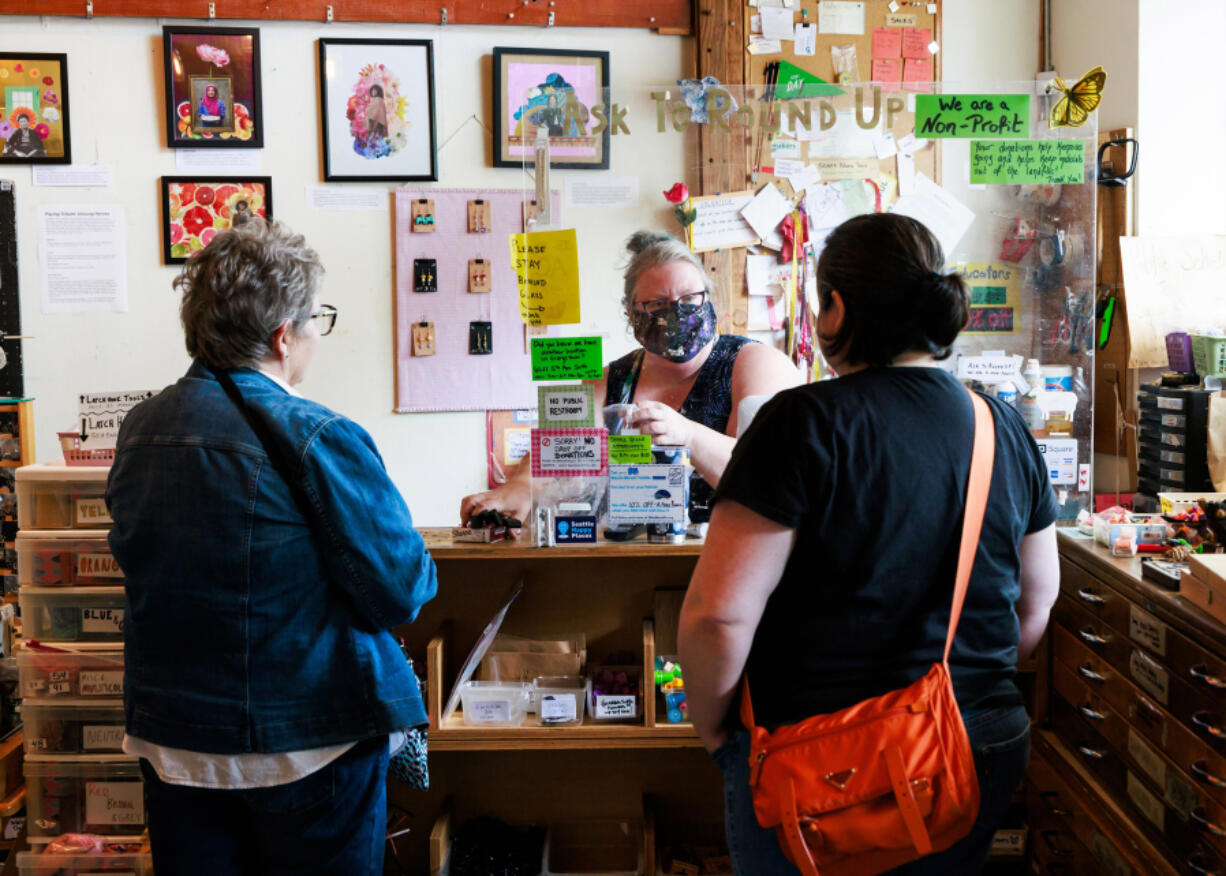 Tamera Mickelson, a retail associate and working artist, checks out customers Aug. 16 at Seattle ReCreative, a nonprofit organization, in Greenwood.