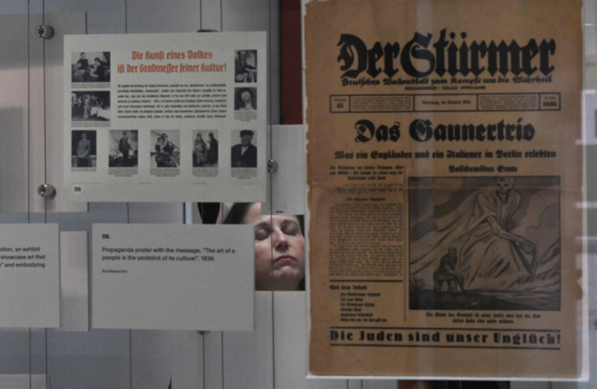 The Zekelman Holocaust Center Director of Education Ruth Bergman, seen through a display, during a tour in Farmington Hills, Michigan, on Aug. 7, 2024.