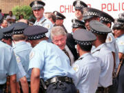 Then-President Bill Clinton, center, greets newly hired Chicago police officers on June 30, 1995, during an award ceremony for Clinton given by the Illinois Council Against Handgun Violence in Chicago. The officers were hired with federal funds from Clinton&Ccedil;&fnof;&Ugrave;s Crime Bill. (Paul J.