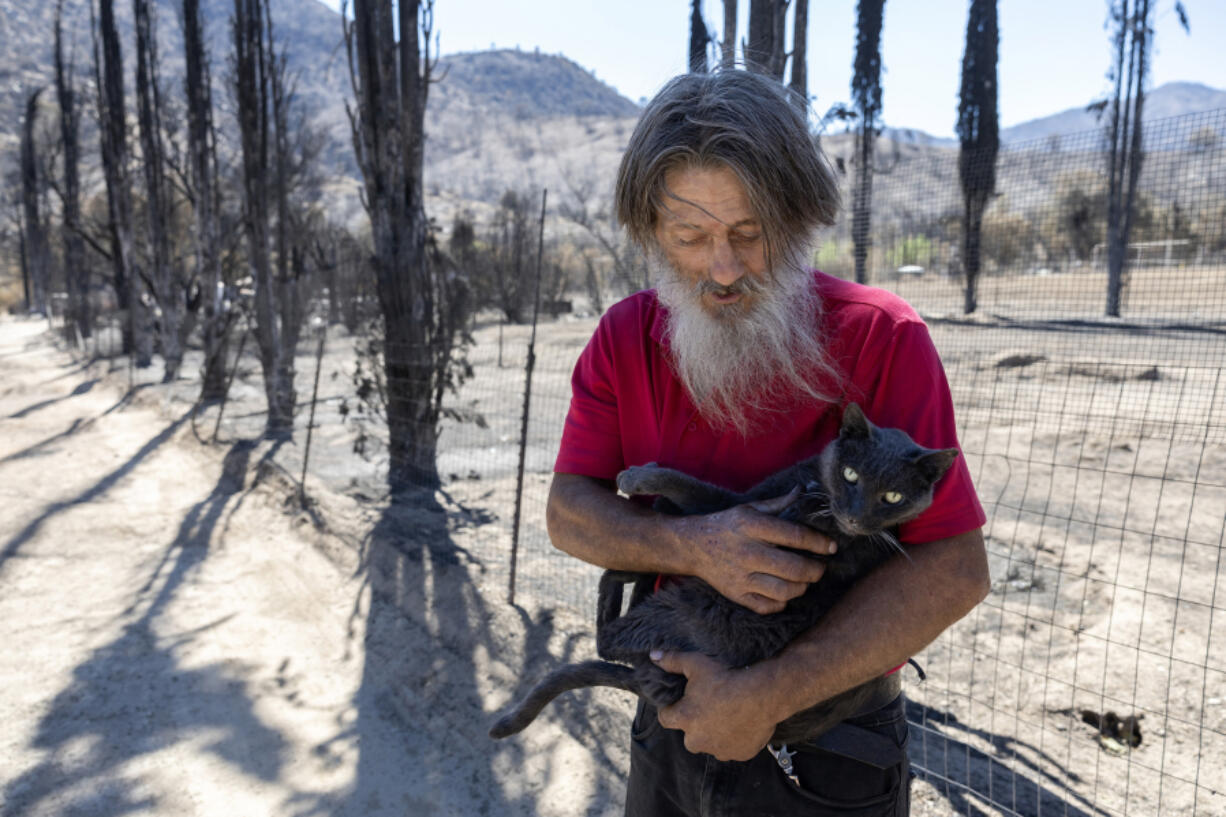 Daniel Gonzales, 64, was excited to be reunited with his cat, which he calls Fat Ass, after the cat had gone missing for nearly three weeks, following the start of the Borel fire, in Havilah, California, in Kern County on Wednesday, Aug. 14, 2024. (Myung J.