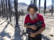 Daniel Gonzales, 64, was excited to be reunited with his cat, which he calls Fat Ass, after the cat had gone missing for nearly three weeks, following the start of the Borel fire, in Havilah, California, in Kern County on Wednesday, Aug. 14, 2024. (Myung J.