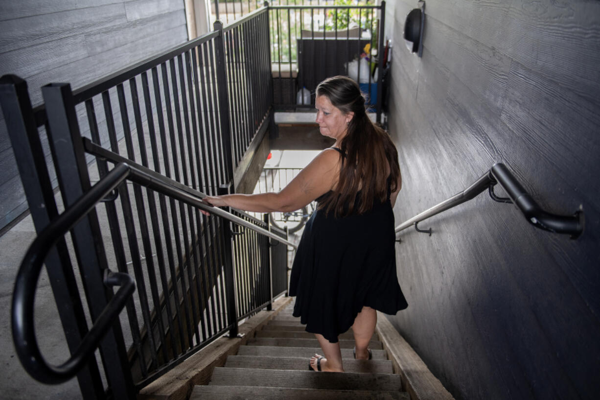 Heidi Leonard of Vancouver walks downstairs through her apartment building complex. Leonard lives at The Pacific and said the supportive housing needs more security and accountability.