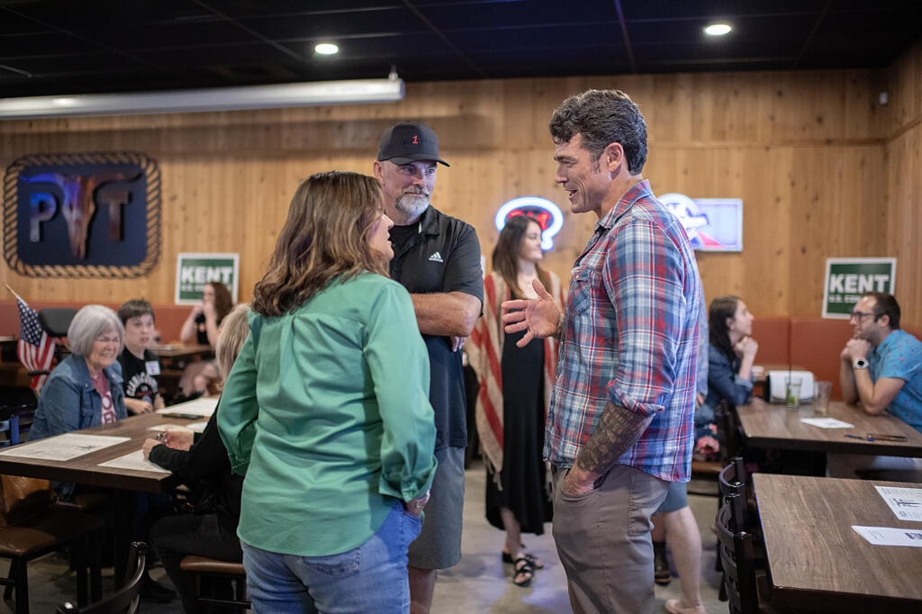 Lauren Colas of Camas, from left, and Mark Moore of Vancouver chat with candidate Joe Kent during a primary election party at Prairie Tavern on Tuesday evening, Aug. 6, 2024.