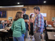 Lauren Colas of Camas, from left, and Mark Moore of Vancouver chat with candidate Joe Kent during a primary election party at Prairie Tavern on Tuesday evening, Aug. 6, 2024.