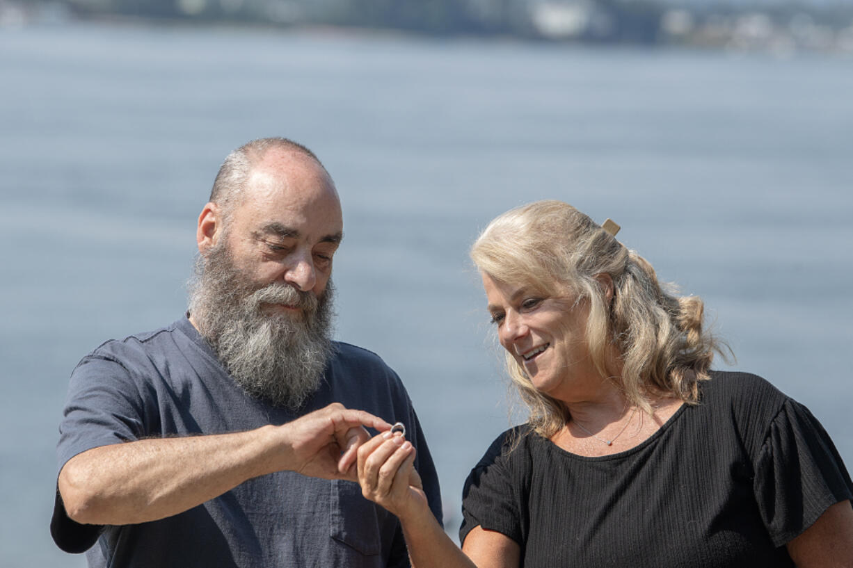 Metal detectorist Craig Nichols, left, and Barbara James, Fort Vancouver High School Class of 1981, look over her class ring at Wintler Park last week. Nichols recovered and returned the ring that had been missing for 42 years.