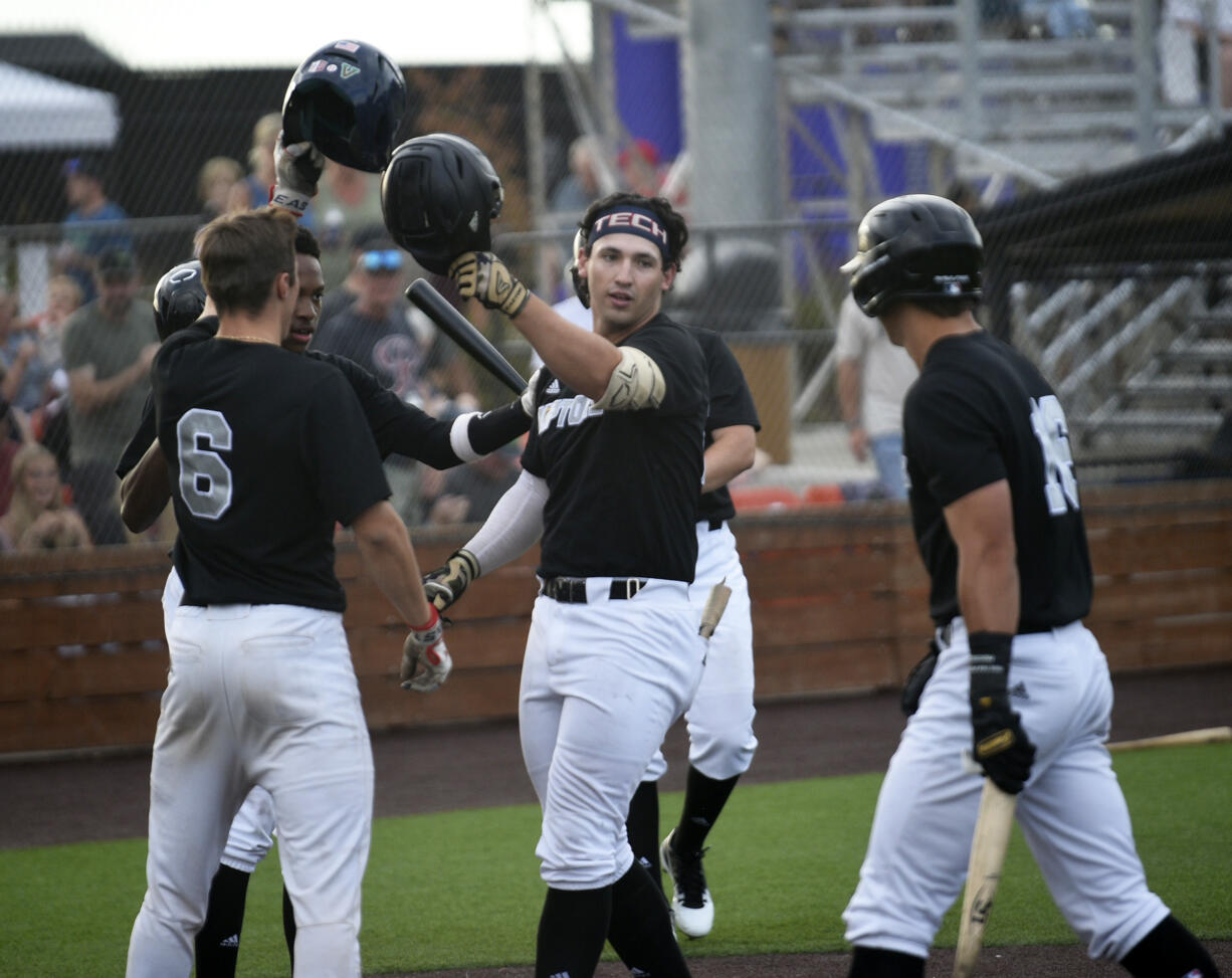 Hunter Katschke of the Ridgefield Raptors is greeted at home plate by his teammates after hitting a three-run home run in the first inning of the Raptors' game against the Springfield Drifters at the Ridgefied Outdoor Recreation Center on Saturday, Aug. 3, 2024.