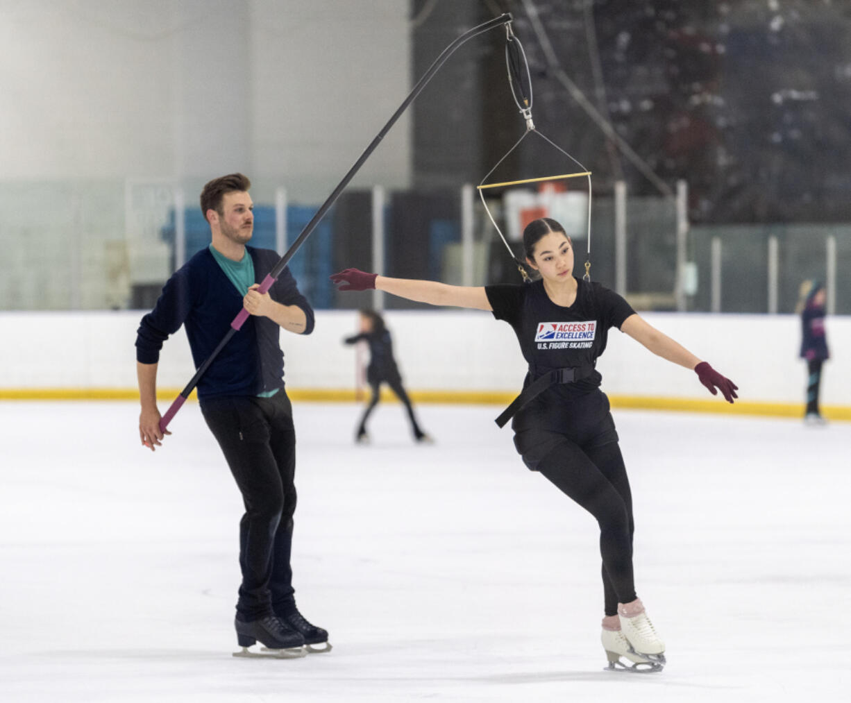 Instructor Joe Gorecki, left, works with Natasha Saladin, 17,  in a jumping harness Thursday at Mountain View Ice Arena.