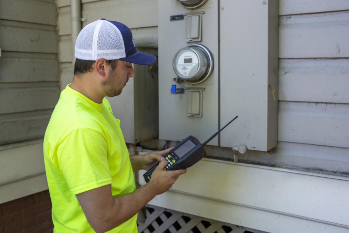 Clark Public Utilities employee Jacob Bishop reads a meter in this 2019 photo. The utility is in the process of implementing a new advanced metering system.