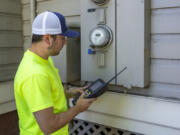 Clark Public Utilities employee Jacob Bishop reads a meter in this 2019 photo. The utility is in the process of implementing a new advanced metering system.