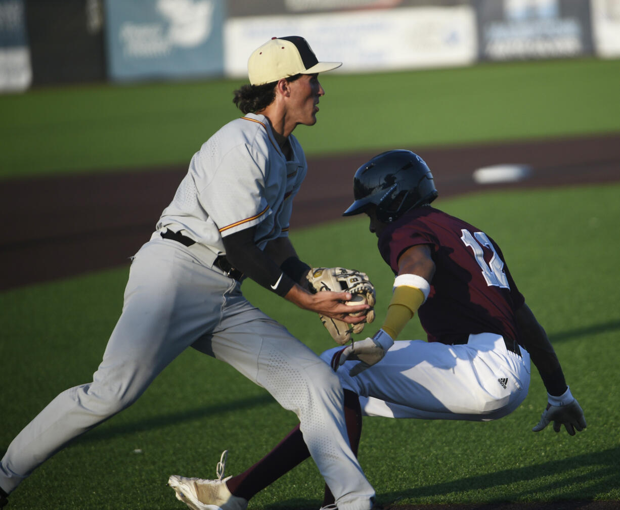 Dasan Harris of the Ridgefield Raptors (right) falls down after being tagged out by Thomas Ferroggiaro of the Corvallis Knights in the second inning of a West Coast League playoff game at the Ridgefield Outdoor Recreation Center on Saturday, Aug. 10, 2024.