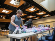 Volunteers Morgan May, left, and Jessica Erick place bags of hygienic items on a table Thursday during a Treehouse pop-up shop at Clark College. The nonprofit event was set up for foster youth to pick out backpacks, new clothes and school supplies in person before the new school year begins.