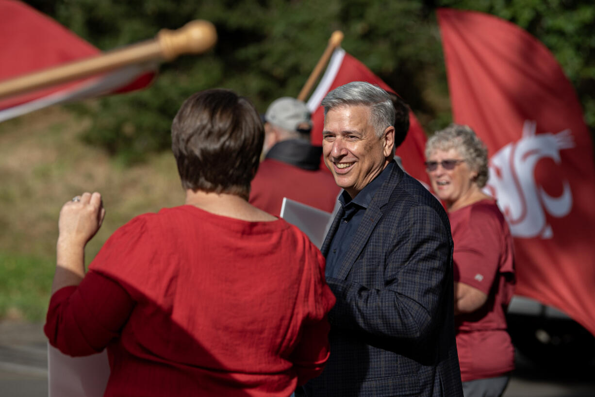 Washington State University Vancouver Chancellor Mel Netzhammer joins faculty and supporters in celebrating a new school year Aug. 19. Netzhammer announced Wednesday morning he will step down from his position next summer after 13 years on the job.