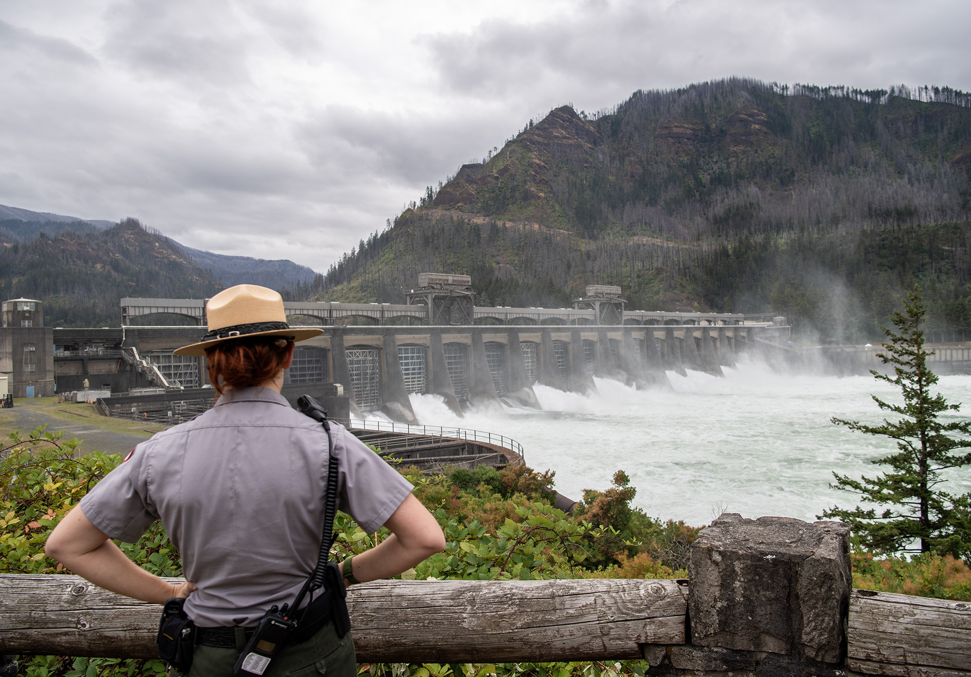 Park Ranger Meg Sleeper looks over at the Bonneville Dam spillway Thursday, Aug. 22, 2024, at Bonneville Dam. National Hydropower day is Aug. 24.