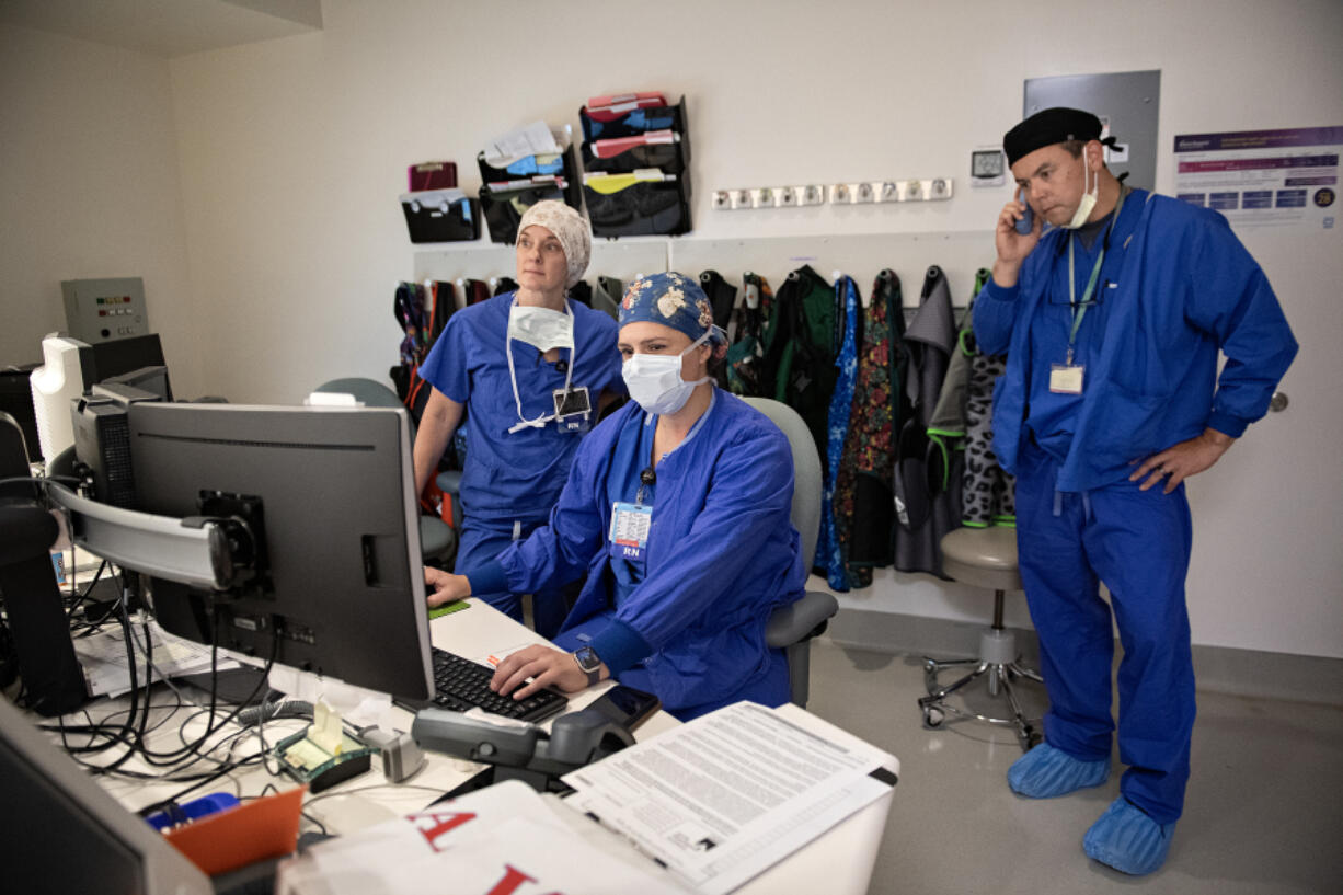 Registered nurse Heather Free, from left, works with fellow registered nurses Kayla Kiest-Lundeen and Michael Davidchik in the cardiac services unit at Legacy Salmon Creek Medical Center.