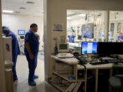 Registered nurse John McPherson, second from left, works with colleagues as they prepare for a patient in the cardiac services unit at Legacy Salmon Creek Medical Center on Thursday morning.