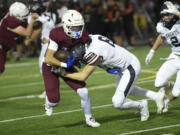 Prairie junior Jackson Kimball is hit by King's Way Christian junior Sam Somarakis (8) during a preseason football jamboree at District Stadium in Battle Ground on Friday, Aug. 30, 2024.