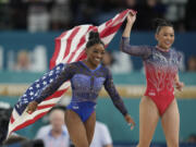 Simone Biles, left, celebrates with teammate Suni Lee, of the United States, after winning the gold and bronze medals respectively in the women's artistic gymnastics all-around finals in Bercy Arena at the 2024 Summer Olympics, Thursday, Aug. 1, 2024, in Paris, France.