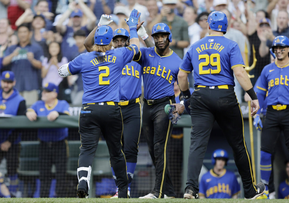 Seattle Mariners' Justin Turner (2) celebrates at home after his grand slam off Philadelphia Phillies starting pitcher Tyler Phillips during the second inning in a baseball game, Friday, Aug. 2, 2024, in Seattle.