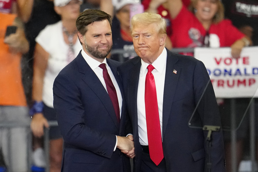 Republican vice presidential candidate Sen. JD Vance, R-Ohio, left, and Republican presidential candidate former President Donald Trump, shake hands at a campaign rally at Georgia State University in Atlanta, Saturday, Aug.