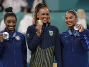 Gold medalist Rebeca Andrade, center, of Brazil, celebrates on the podium with silver medalist Simone Biles, left, of the United States, and Jordan Chiles, also of the United States, during medal ceremony for the women's artistic gymnastics individual floor finals at Bercy Arena at the 2024 Summer Olympics, Monday, Aug. 5, 2024, in Paris, France.