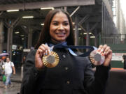 Two-time U.S. Olympic gymnast medalist Jordan Chiles shows her medals after ringing the closing bell at the Nasdaq MarketSite, in New York's Times Square, Thursday, Aug. 8, 2024.