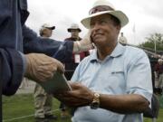 FILE - Chi Chi Rodriguez, of Puerto Rico, smiles while signing an autograph at the Nashawtuc Country Club in Concord, Mass., Friday, June 9, 2006.