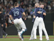 Seattle Mariners outfielder Mitch Haniger, center, is mobbed by Luke Raley, right, and Cal Raleigh (29) after Hanger's three-RBI, walk-off double during the ninth inning of a baseball game against the Detroit Tigers, Thursday, Aug. 8, 2024, in Seattle. The Mariners won 4-3.