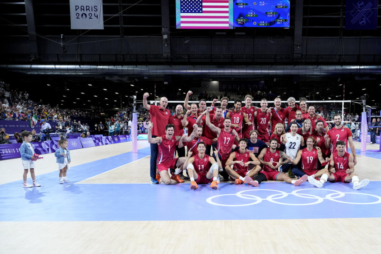 The children of United States' player Matthew Anderson look at the team posing for a photo after winning the men's volleyball bronze medal match against Italy at the 2024 Summer Olympics, Friday, Aug. 9, 2024, in Paris, France.