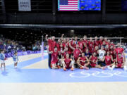 The children of United States' player Matthew Anderson look at the team posing for a photo after winning the men's volleyball bronze medal match against Italy at the 2024 Summer Olympics, Friday, Aug. 9, 2024, in Paris, France.