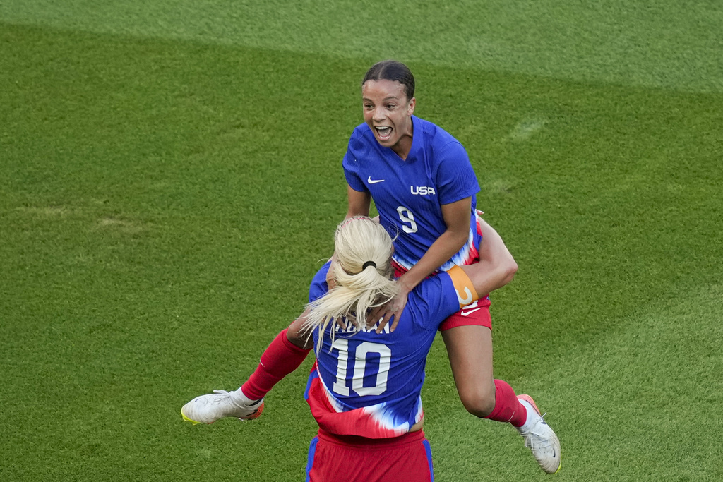 Mallory Swanson, of the United States, up, celebrates with Lindsey Horan, of the United States, after scoring her side's first goal during the women's soccer gold medal match between Brazil and the United States at the Parc des Princes during the 2024 Summer Olympics, Saturday, Aug. 10, 2024, in Paris, France.