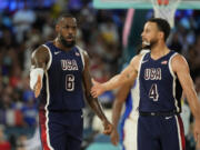 United States' LeBron James (6) and United States' Stephen Curry (4) celebrates after scoring a basket against France during a men's gold medal basketball game at Bercy Arena at the 2024 Summer Olympics, Saturday, Aug. 10, 2024, in Paris, France. (AP Photo/Mark J.