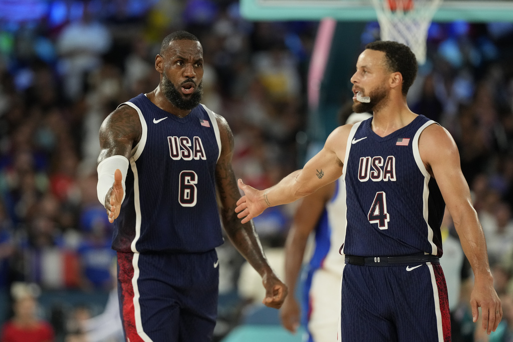 United States' LeBron James (6) and United States' Stephen Curry (4) celebrates after scoring a basket against France during a men's gold medal basketball game at Bercy Arena at the 2024 Summer Olympics, Saturday, Aug. 10, 2024, in Paris, France. (AP Photo/Mark J.