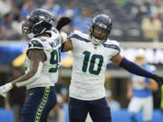 Seattle Seahawks defensive end Leonard Williams (99) reacts with linebacker Uchenna Nwosu (10) during the first half of a preseason NFL football game against the Los Angeles Chargers in Inglewood, Calif., Saturday, Aug. 10, 2024.