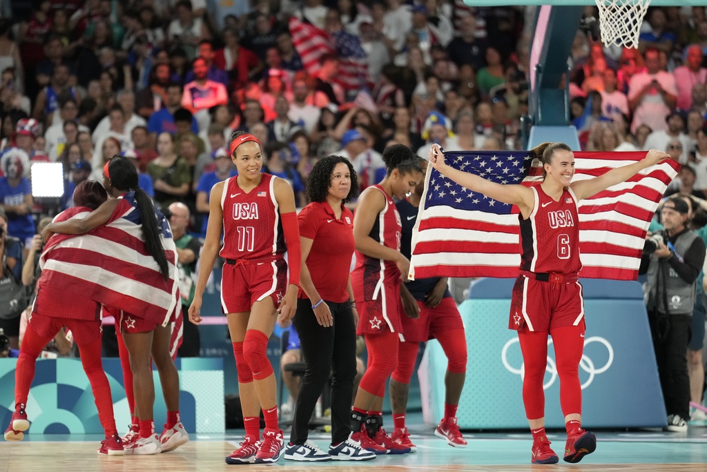 The United States team celebrates after a women's gold medal basketball game at Bercy Arena at the 2024 Summer Olympics, Sunday, Aug. 11, 2024, in Paris, France. (AP Photo/Mark J.