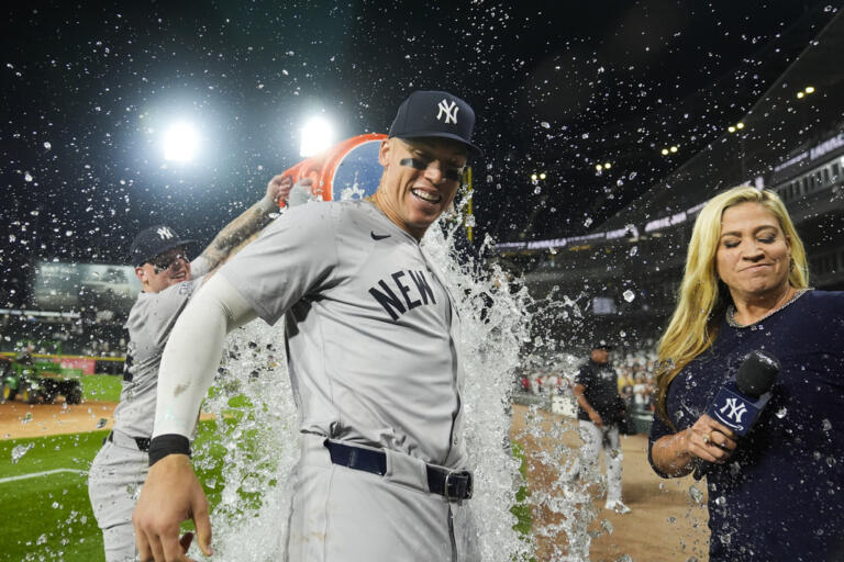 New York Yankees' Aaron Judge is doused by his teammates after he hit his 300th career home run, the fastest player to do so in MLB history, in a baseball game against the Chicago White Sox, Wednesday, Aug. 14, 2024, in Chicago.