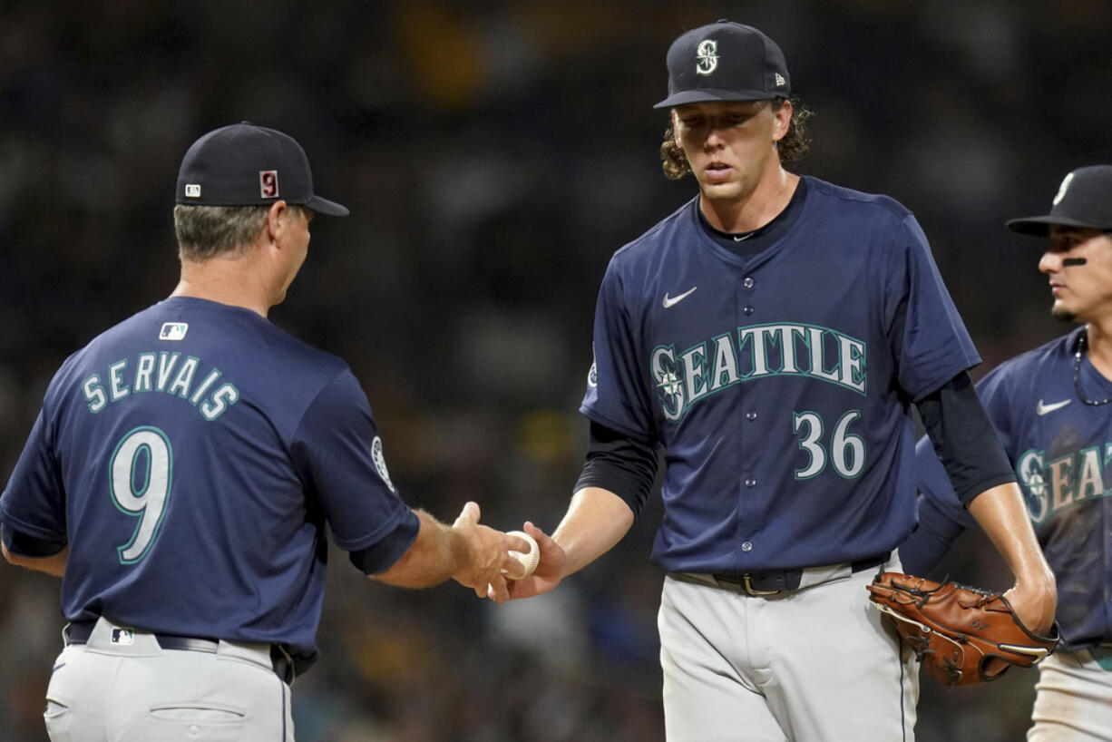 Seattle Mariners starting pitcher Logan Gilbert (36) hands the ball to manager Scott Servais, left, during the seventh inning of a baseball game against the Pittsburgh Pirates, Friday, Aug. 16, 2024, in Pittsburgh.