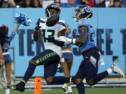 Seattle Seahawks wide receiver Easop Winston Jr. (13) catches a 23-yard touchdown pass in front of Tennessee Titans cornerback Tre Avery, right, during the first half of an NFL preseason football game, Saturday, Aug. 17, 2024, in Nashville, Tenn.