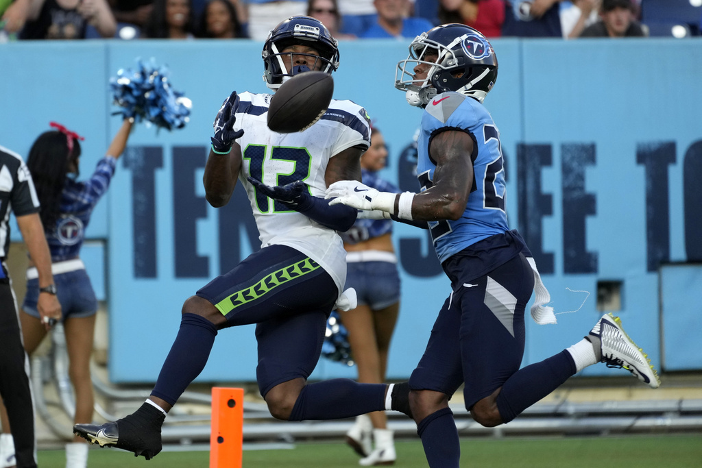 Seattle Seahawks wide receiver Easop Winston Jr. (13) catches a 23-yard touchdown pass in front of Tennessee Titans cornerback Tre Avery, right, during the first half of an NFL preseason football game, Saturday, Aug. 17, 2024, in Nashville, Tenn.