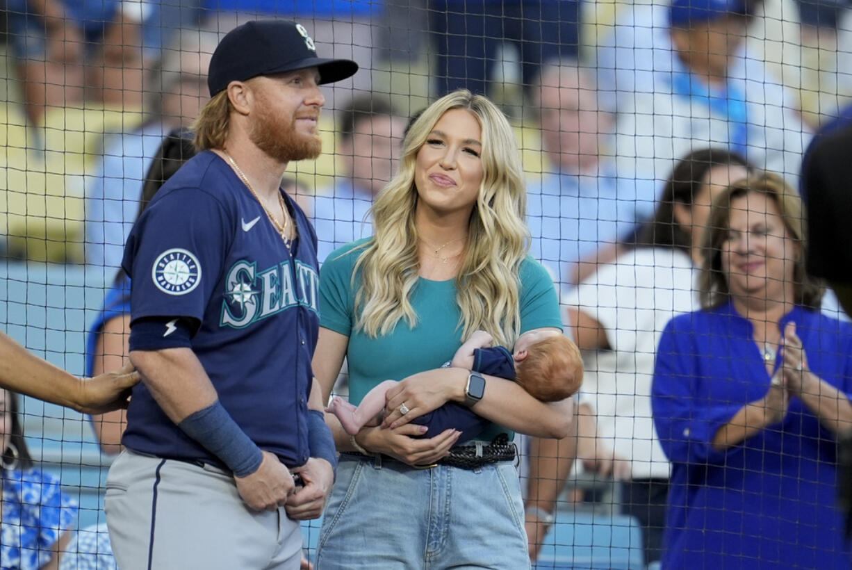 Seattle Mariners' Justin Turner, left, stands next to his wife Kourtney and their infant son Bo, as he is honored before a baseball game against the Los Angeles Dodgers, Monday, Aug. 19, 2024, in Los Angeles.