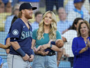 Seattle Mariners' Justin Turner, left, stands next to his wife Kourtney and their infant son Bo, as he is honored before a baseball game against the Los Angeles Dodgers, Monday, Aug. 19, 2024, in Los Angeles.