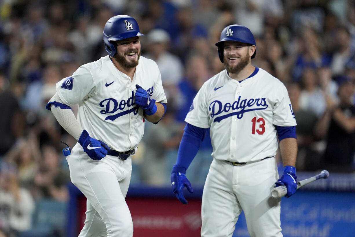 Los Angeles Dodgers' Gavin Lux, left, celebrates at home plate with Max Muncy (13) after Lux's solo home run against the Seattle Mariners during the seventh inning of a baseball game Monday, Aug. 19, 2024, in Los Angeles.