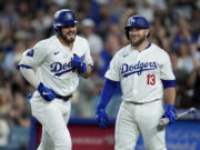 Los Angeles Dodgers' Gavin Lux, left, celebrates at home plate with Max Muncy (13) after Lux's solo home run against the Seattle Mariners during the seventh inning of a baseball game Monday, Aug. 19, 2024, in Los Angeles.